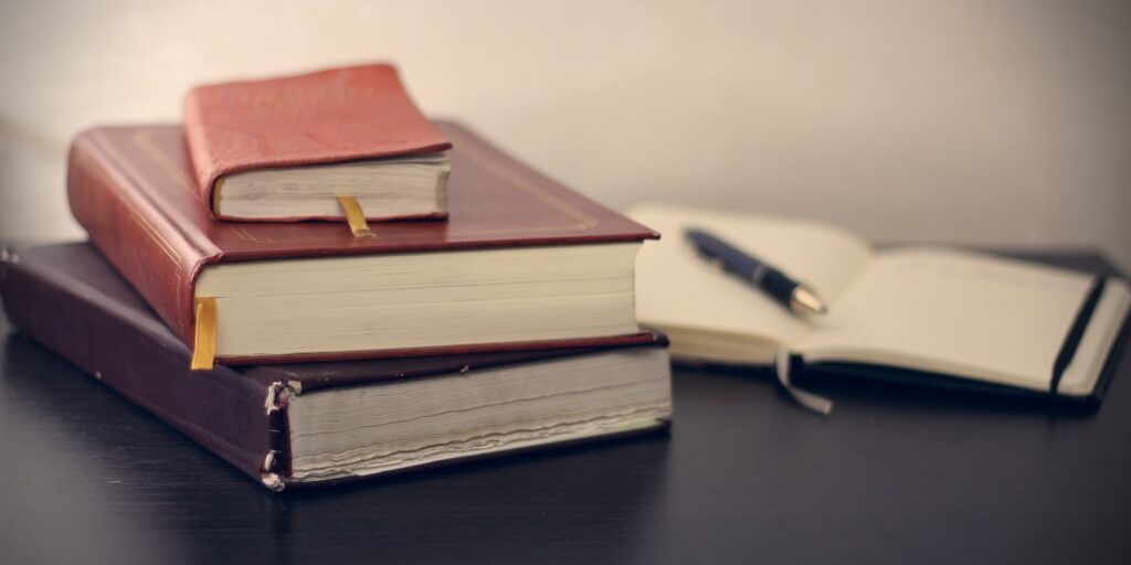 landlord tenant act, selective focus photography of three books beside opened notebook