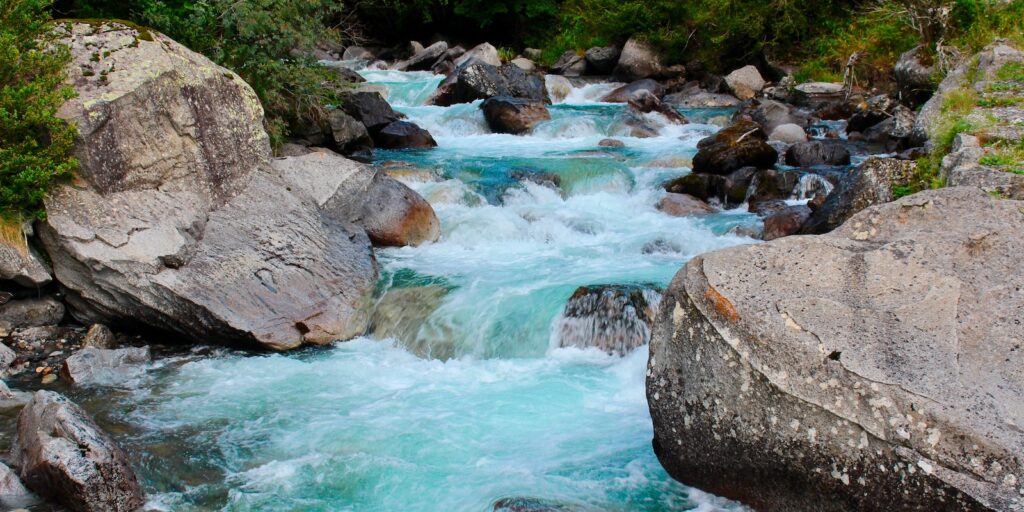 water rights, body of water beside rocks at daytime close-up photography